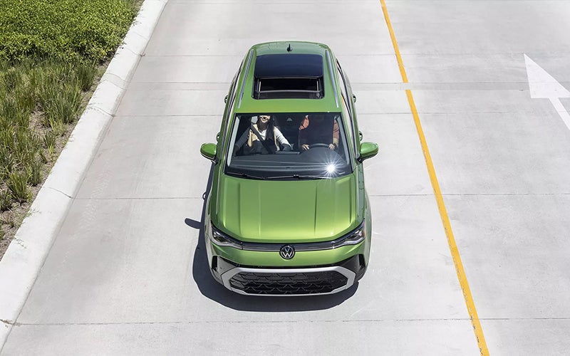 Aerial view of a green Volkswagen SUV driving on a road