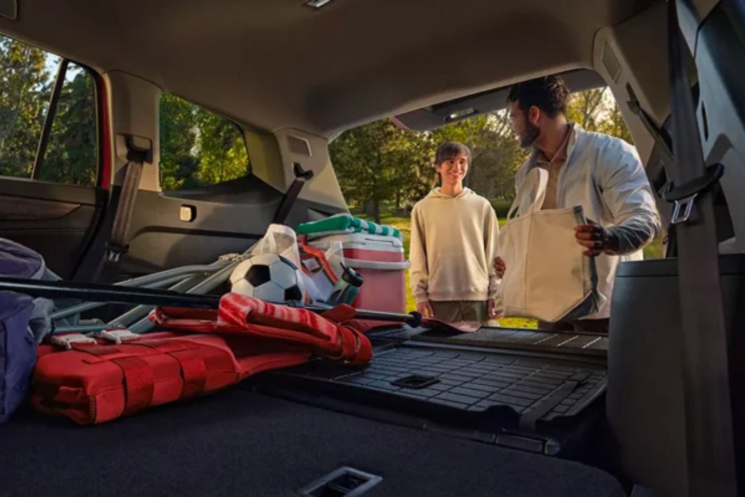 Volkswagen SUV trunk packed with sports gear, two people standing outside